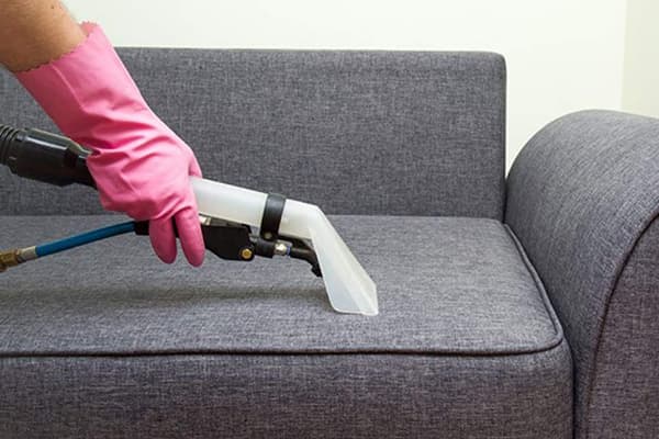 Cleaning the sofa with a steam cleaner