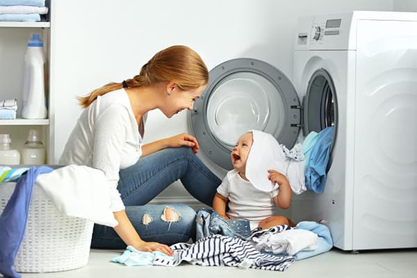 Мама и бебе разделят дрехи след пране