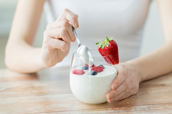 Girl eating low fat yogurt with berries